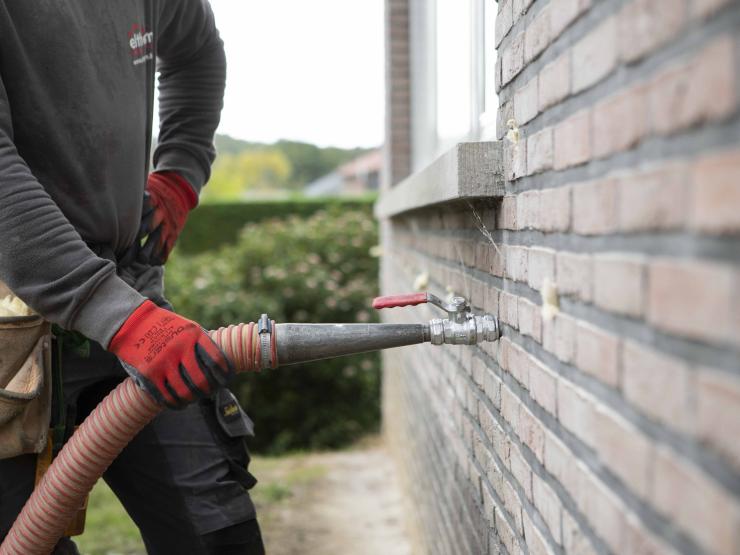 Inspuiten van isolatie in de spouwmuur.
